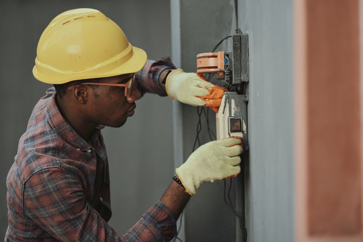 Electrician in a hard hat working on a meter box